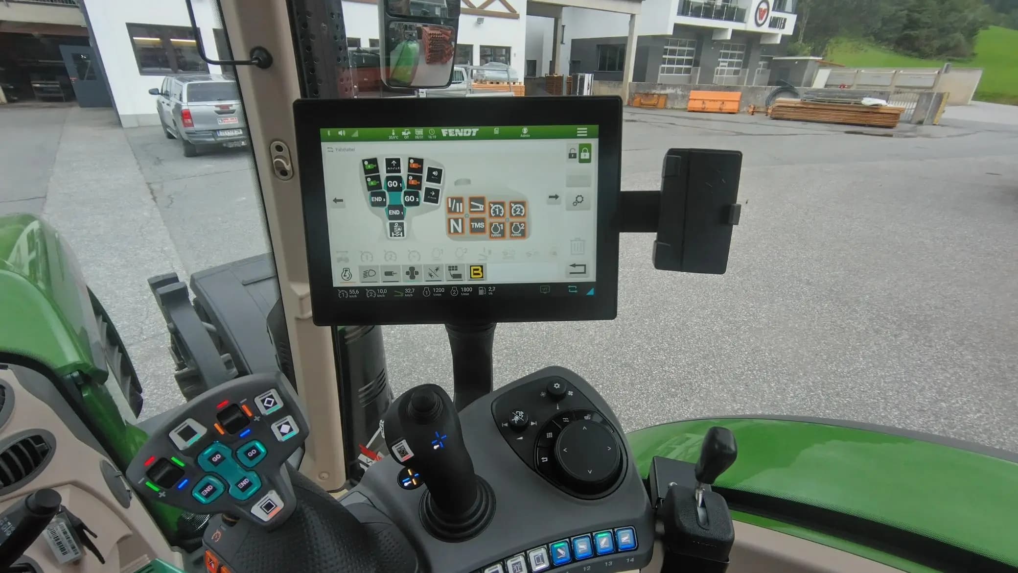 Cab view: the Fendt terminal showing the AUX-N assignment, the joystick in the foreground, and the armrest keypad