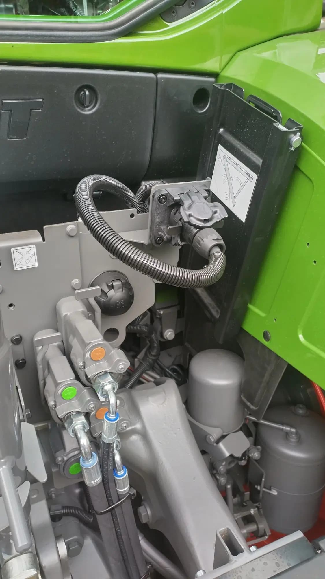 The rear external ISOBUS connector on the tractor above the drawbar, with the ISOBUS supply cable routed down toward the enclosure